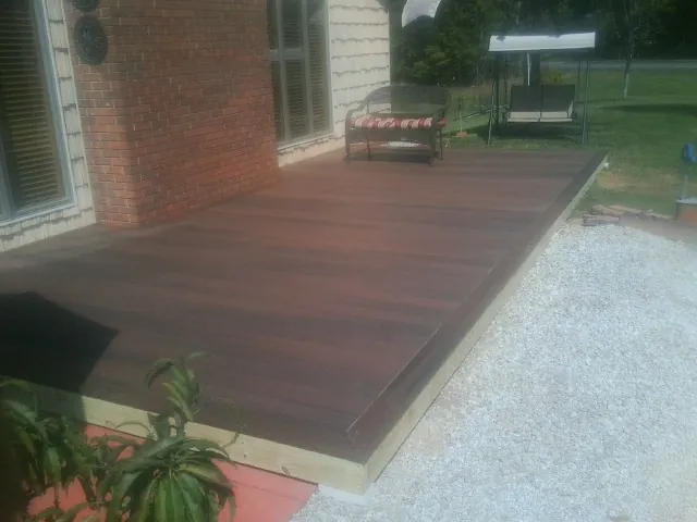 Freshly stained wood deck built against a brick home in Columbia