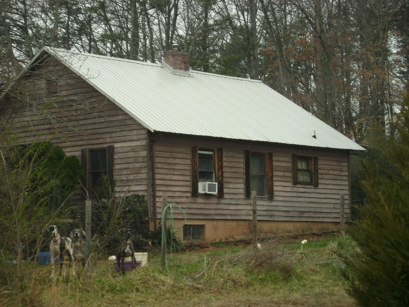 White metal roof on an old wood sided farmhouse, from a Metal Roof Installation job in Columbia